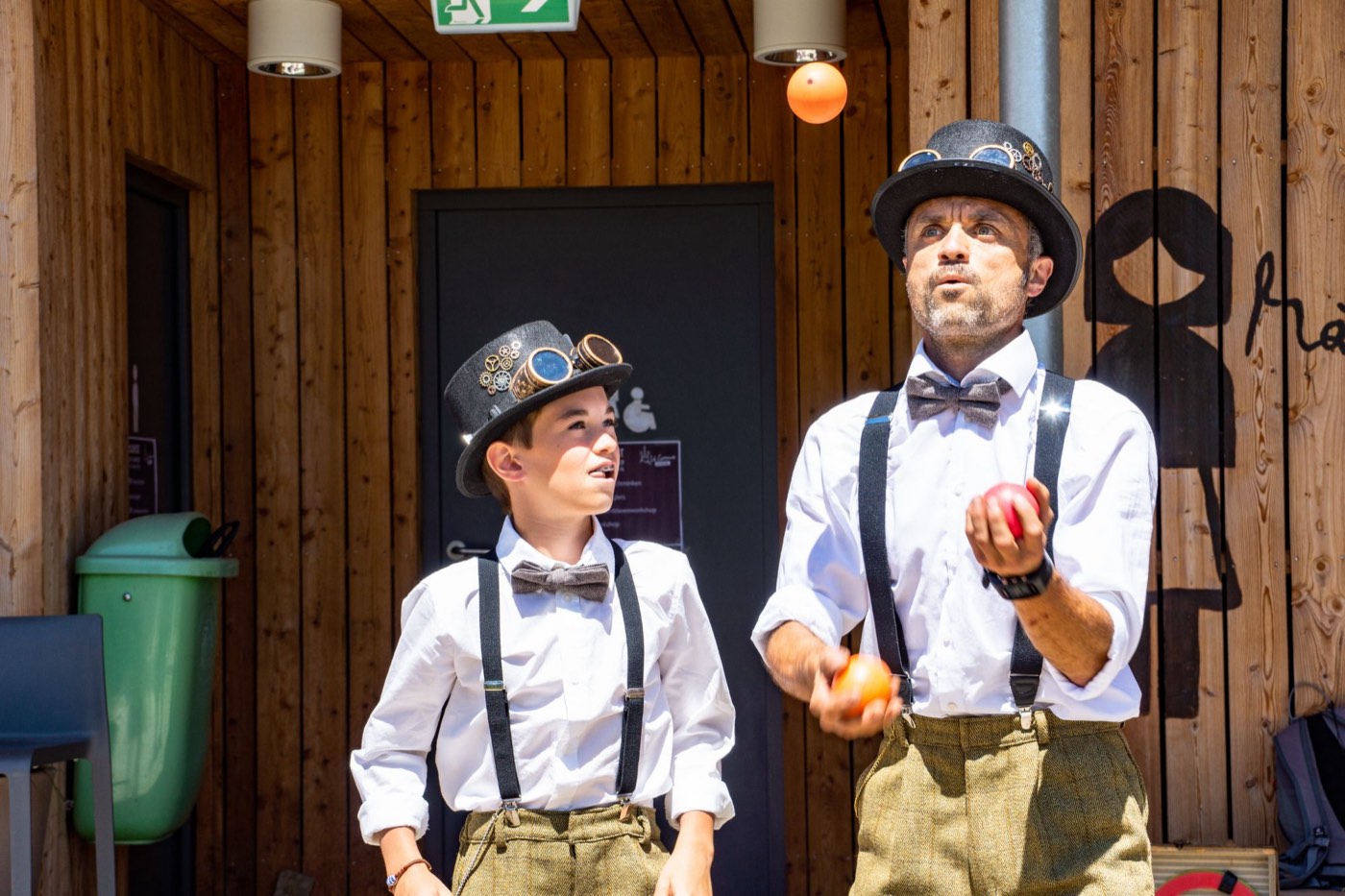 Die Steampunk Jugglers: Leo und sein Sohn Lukas im Steampunk-Kostüm mit Zylinder, Fliege und Hosenträgern jonglieren mit Bällen.